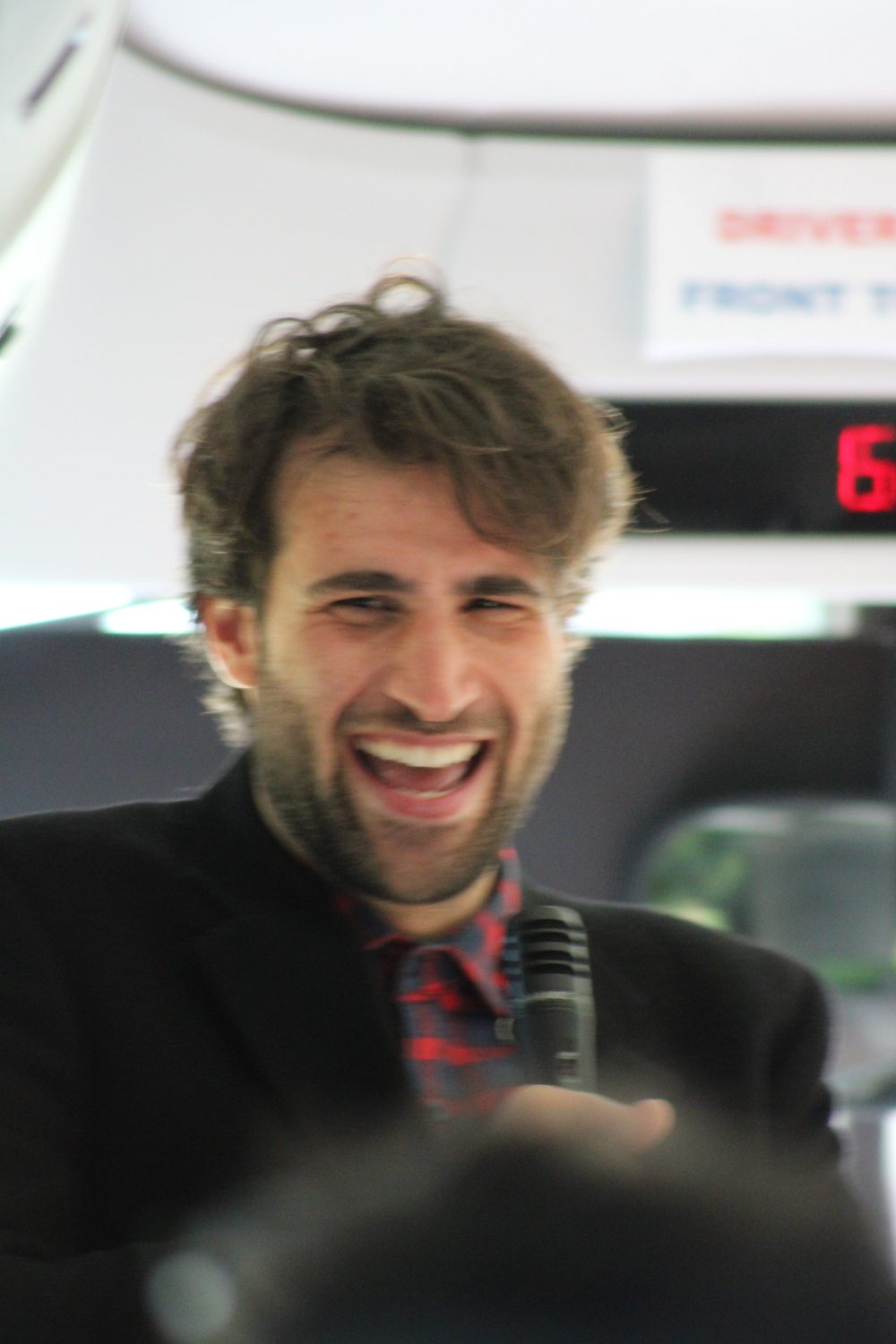 Nabil laughing while guiding a group aboard a private tour, microphone in hand