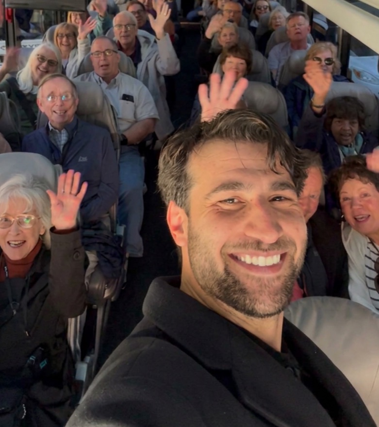 Nabil greeting a large group aboard a coach during a step-on guided tour